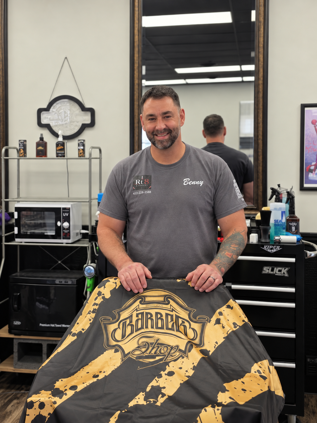 Benny, barber and owner at RT8 Barbers, standing at his station