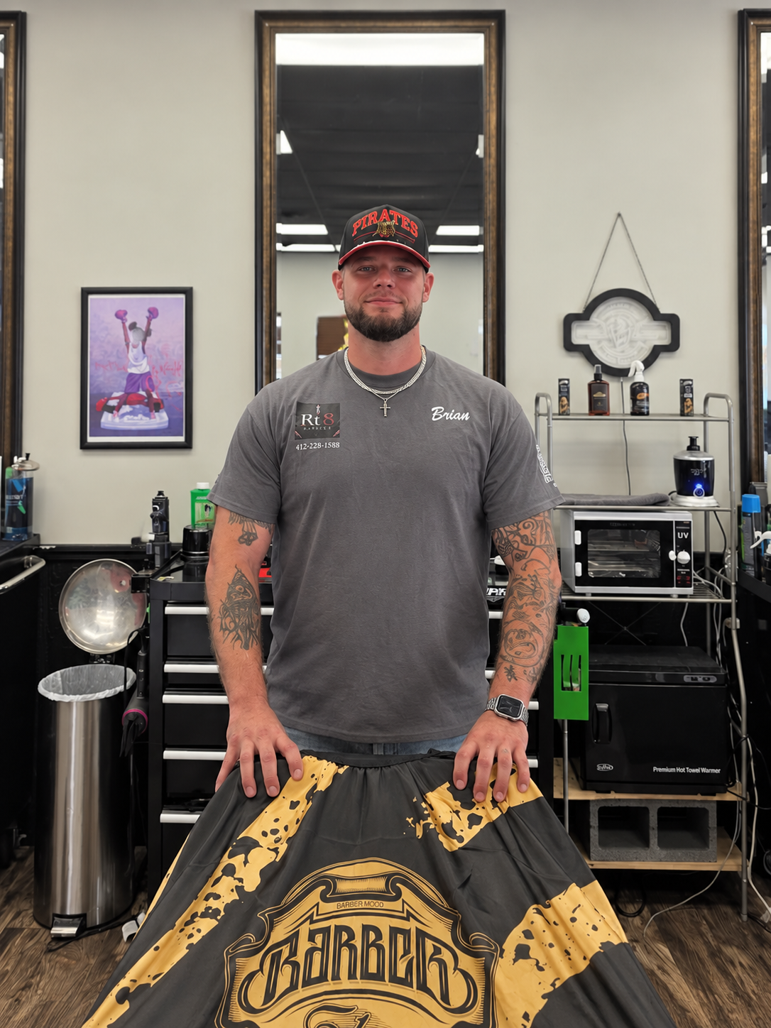Brian, barber at RT8 Barbers, standing at his station