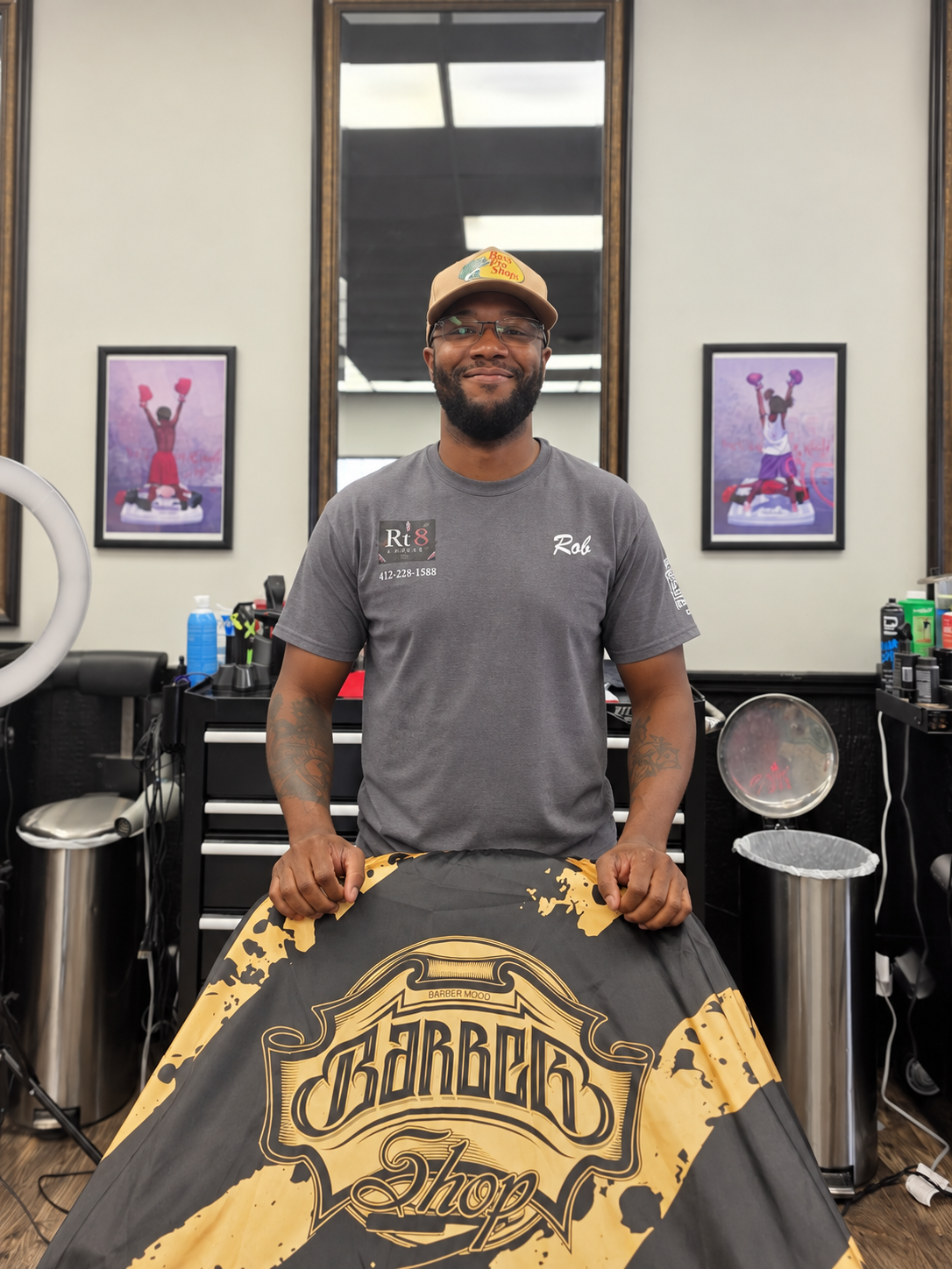 Rob, barber at RT8 Barbers, standing at his station